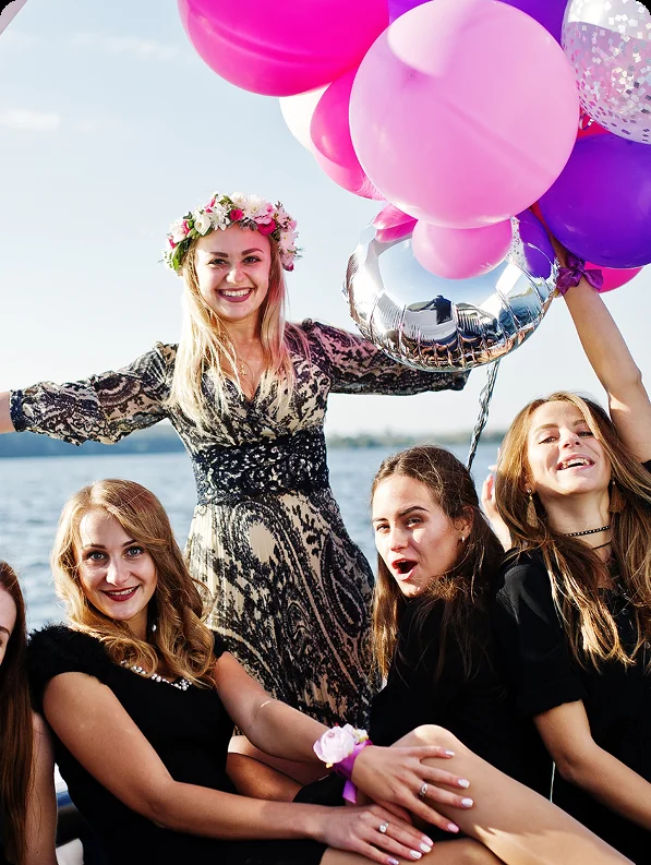Friends celebrating a birthday aboard a yacht with balloons, on a private yacht charter from Auckland