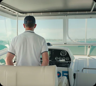 The captain at Liberté's helm, on a private yacht charter from Auckland